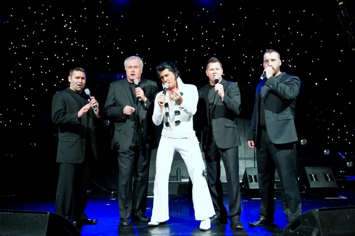 a group of people standing on a stage posing for the camera