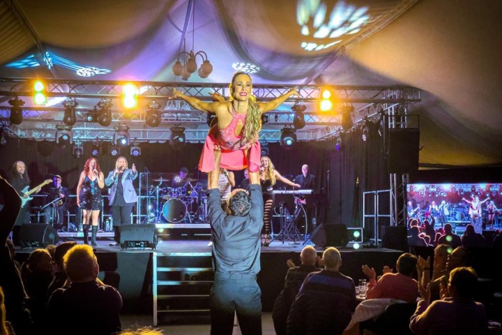 a group of people standing on a stage with a crowd watching