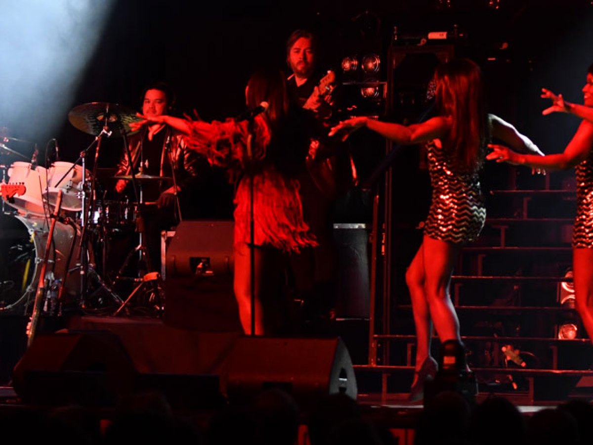 a group of people playing instruments and performing on a stage