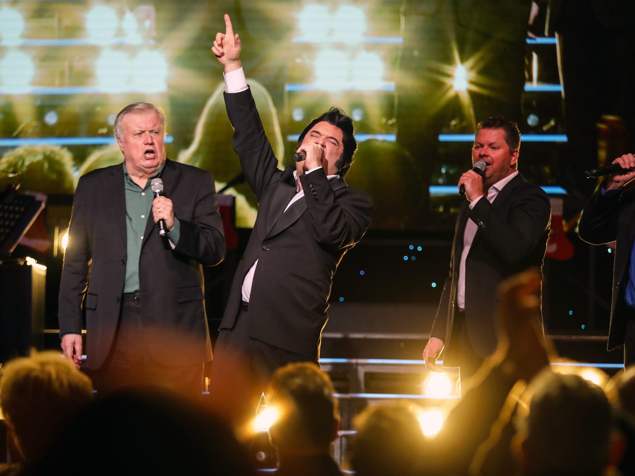 a group of people standing on a stage in front of a crowd