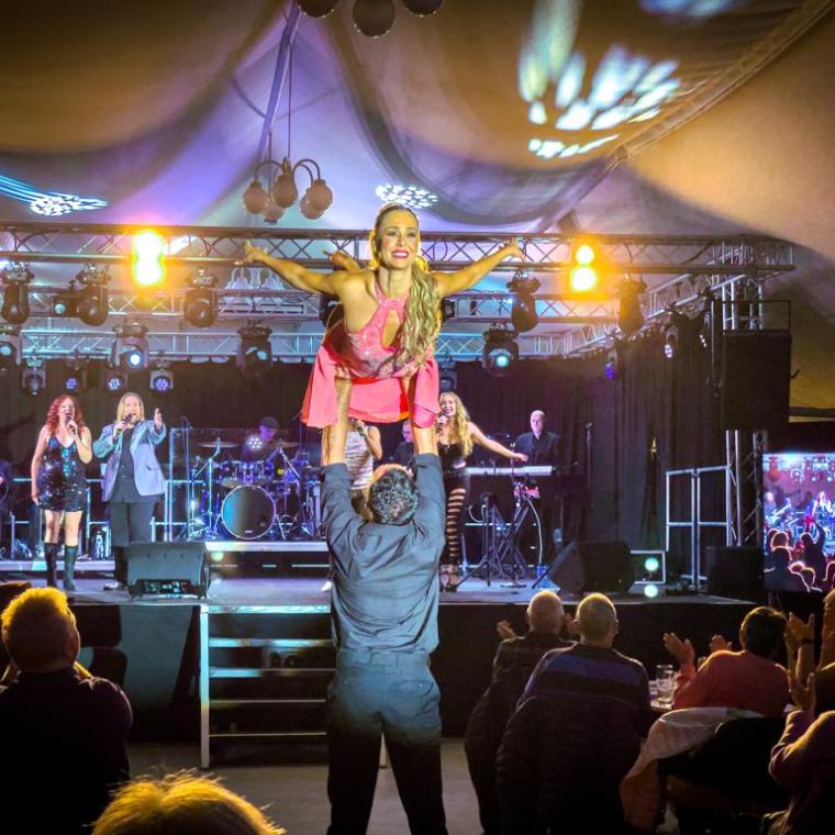 a group of people standing on a stage with a crowd watching