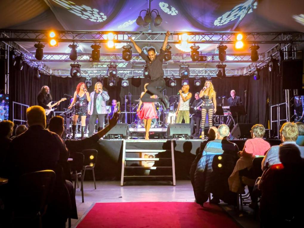 a group of people performing on stage in front of a crowd