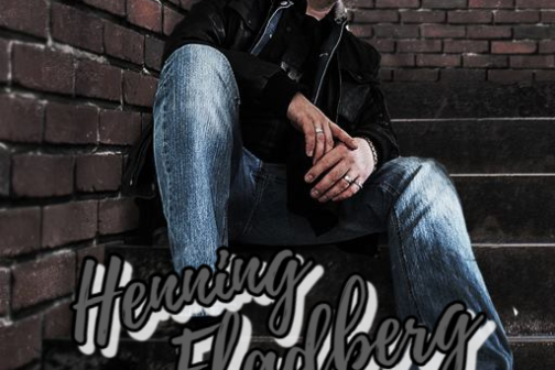 a man sitting on a bench in front of a brick building