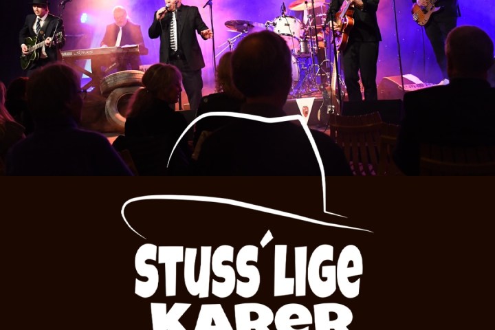 a group of people sitting on stage with stage lights and an audience