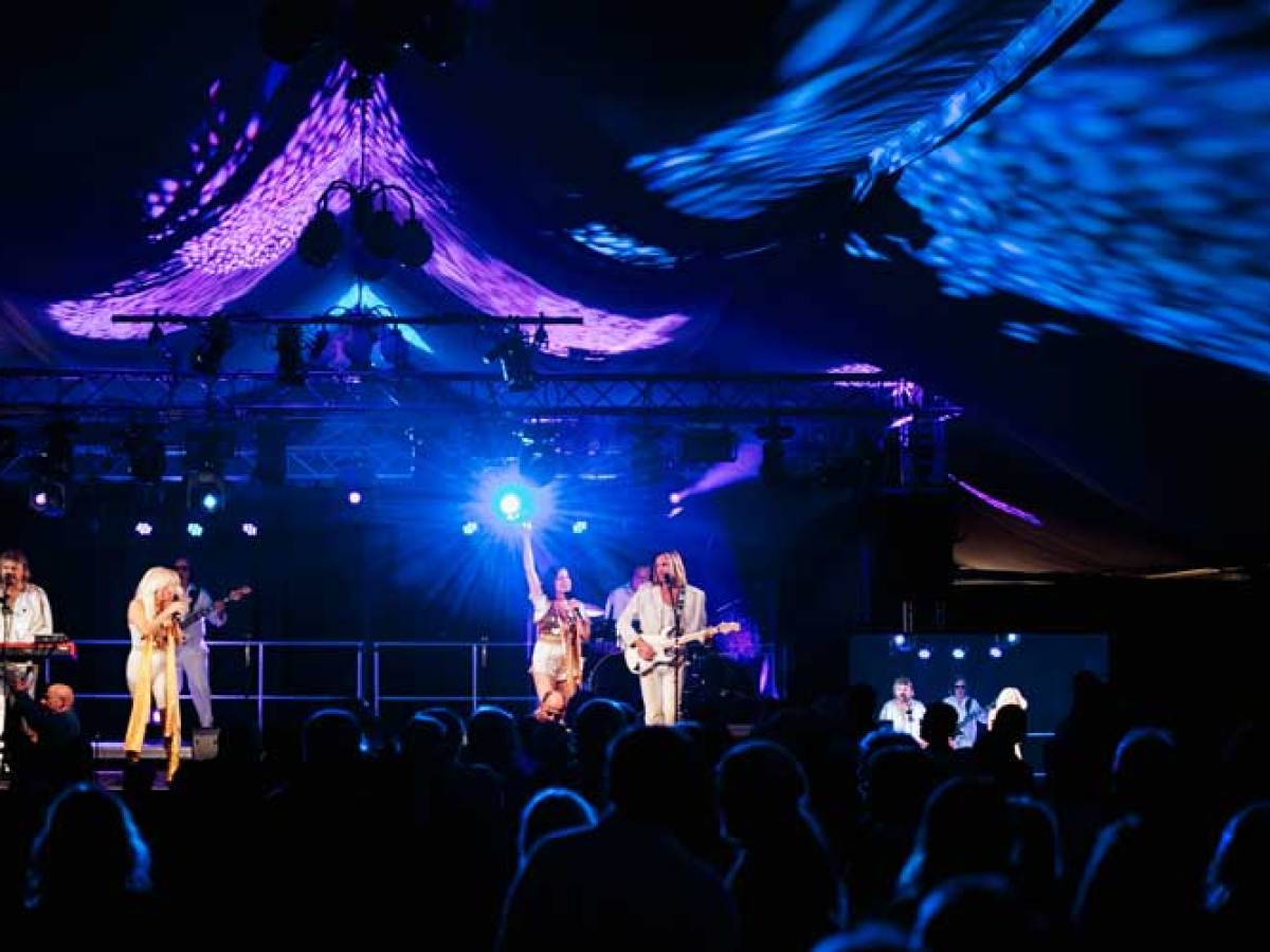 a group of people on a stage with a crowd watching