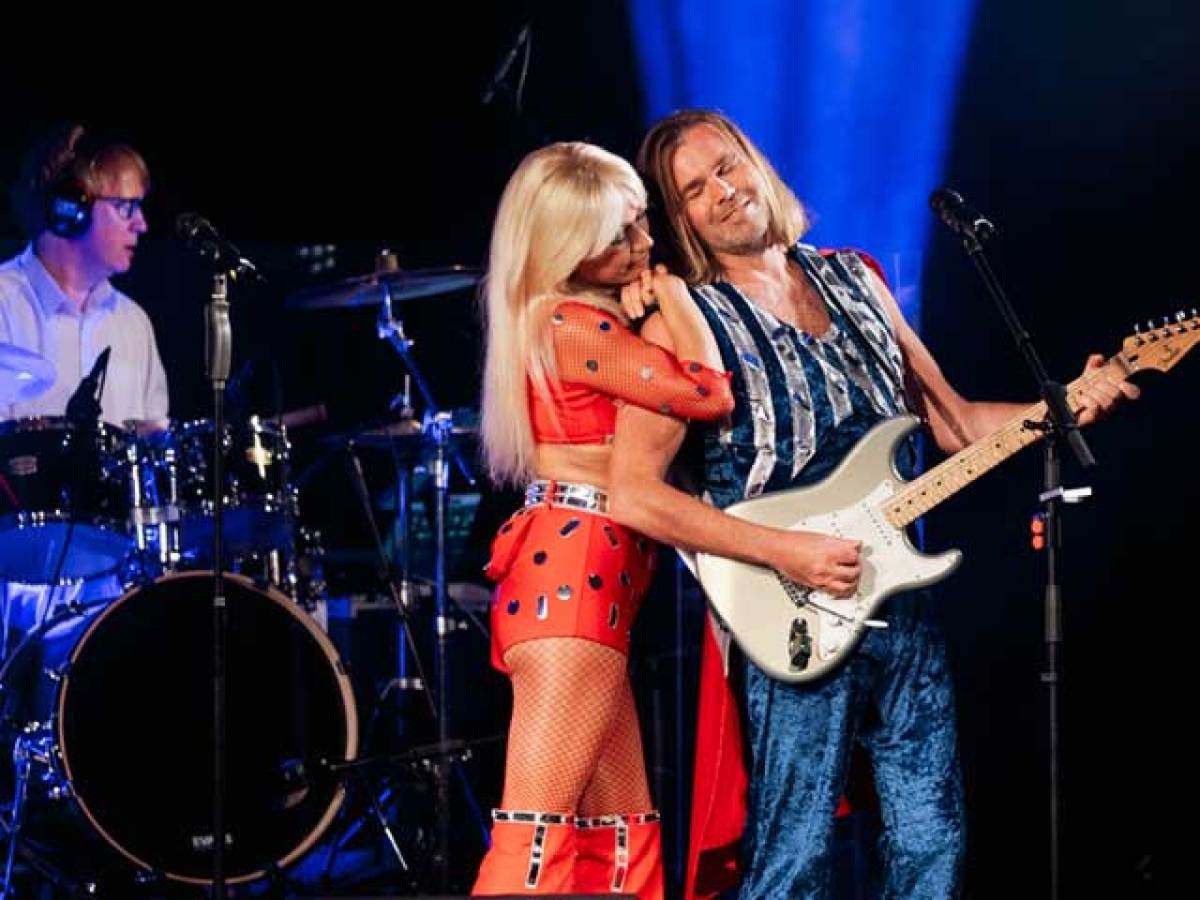 a person standing on a stage playing instruments