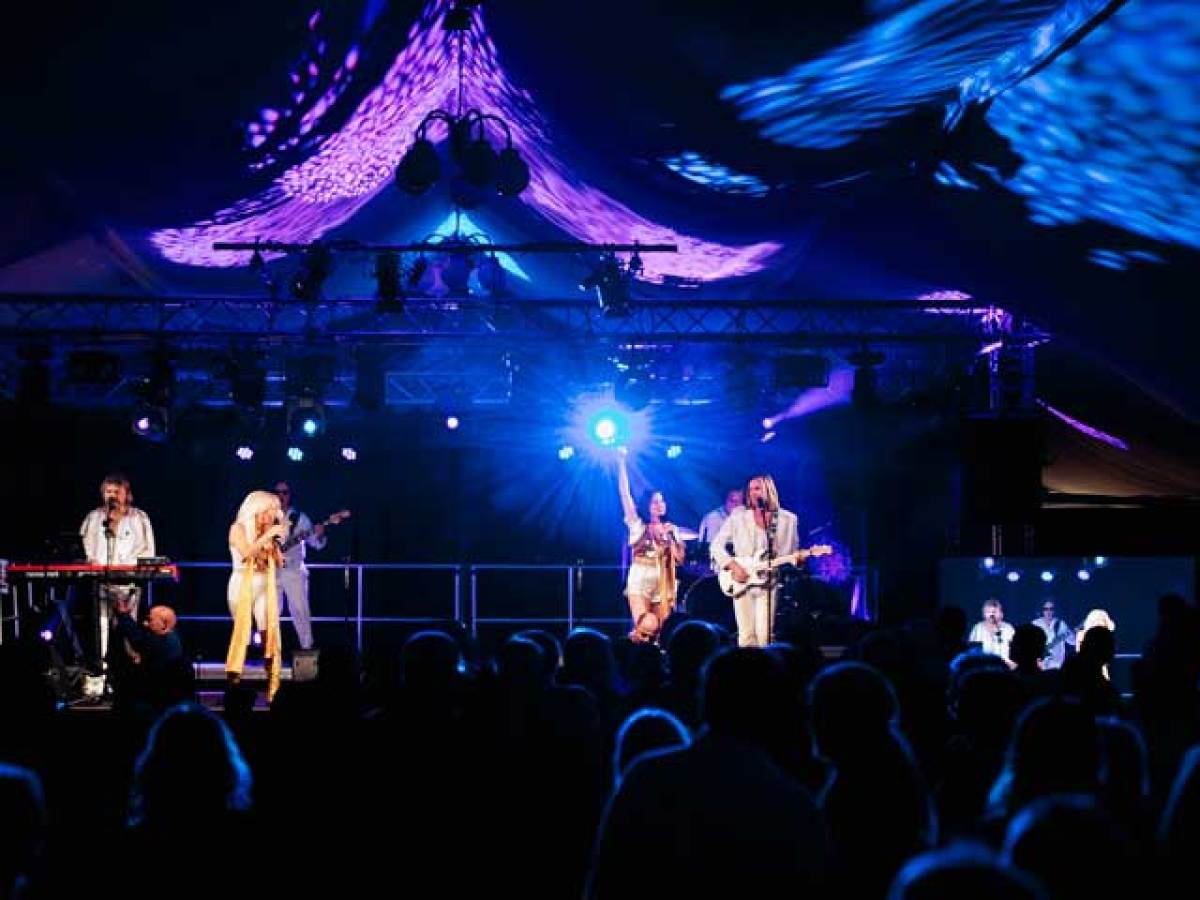 a group of people on a stage with a crowd watching