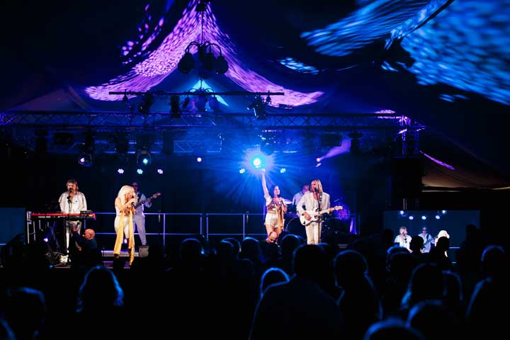 a group of people on a stage with a crowd watching